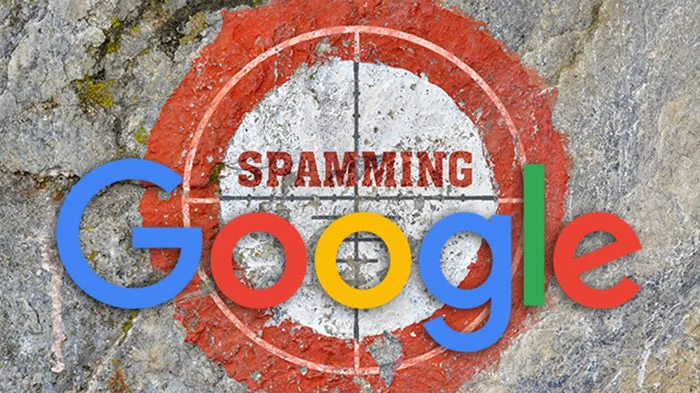 لوگوی Google روی نشانه هدف قرمز با کلمه SPAMMING روی سنگ
